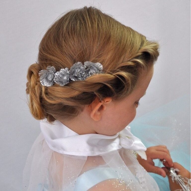 A flower girl's twisted updo finished with silver roses, a tulle cape behind, Wedding Hair And Makeup By Lisa