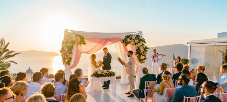 A symbolic ceremony under a draped canopy at sunset in Santorini, Wedding in Greece
