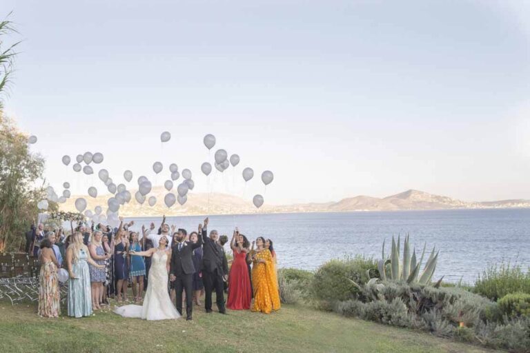 Guests release balloons on a headland above the sea, Wedding in Greece