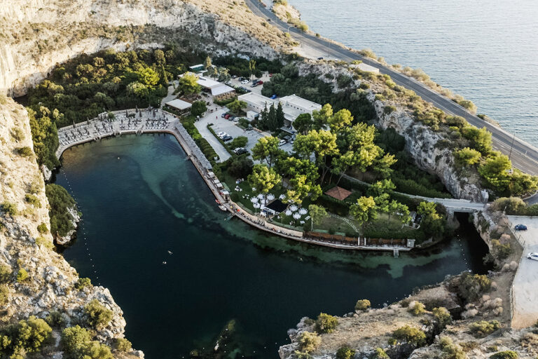 An aerial view of a landscaped venue beside a rock edged lake and the sea, Wedding in Greece