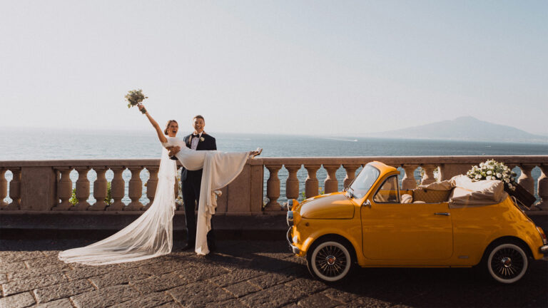 Couple celebrating on a terrace beside the Fiat 500, Sorrento Coast, Wedding In Yellow Vintage