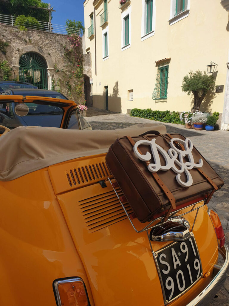 Monogrammed lettering on the antique suitcase at the rear of the car, Wedding In Yellow Vintage