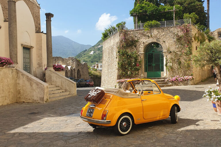 Yellow Fiat 500 parked on a stone lane above the coast, Amalfi Coast, Wedding In Yellow Vintage