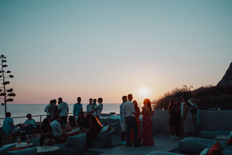 Guests on a terrace above the sea at sunset, Wedding Sicily