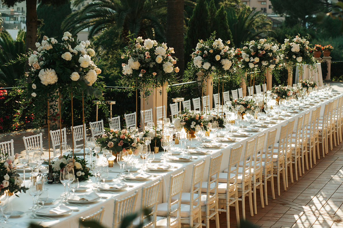 Long table on a terrace dressed with tall arrangements of white roses, Wedding Sicily