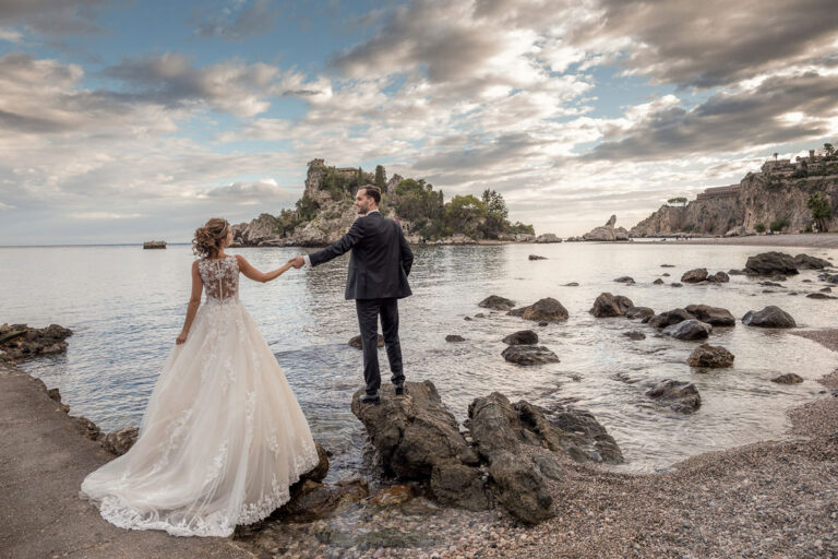 Couple on the rocks of the shoreline at Taormina, Wedding Sicily