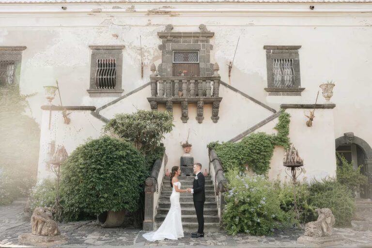 Couple at the foot of the double staircase of a historic villa, Wedding Sicily