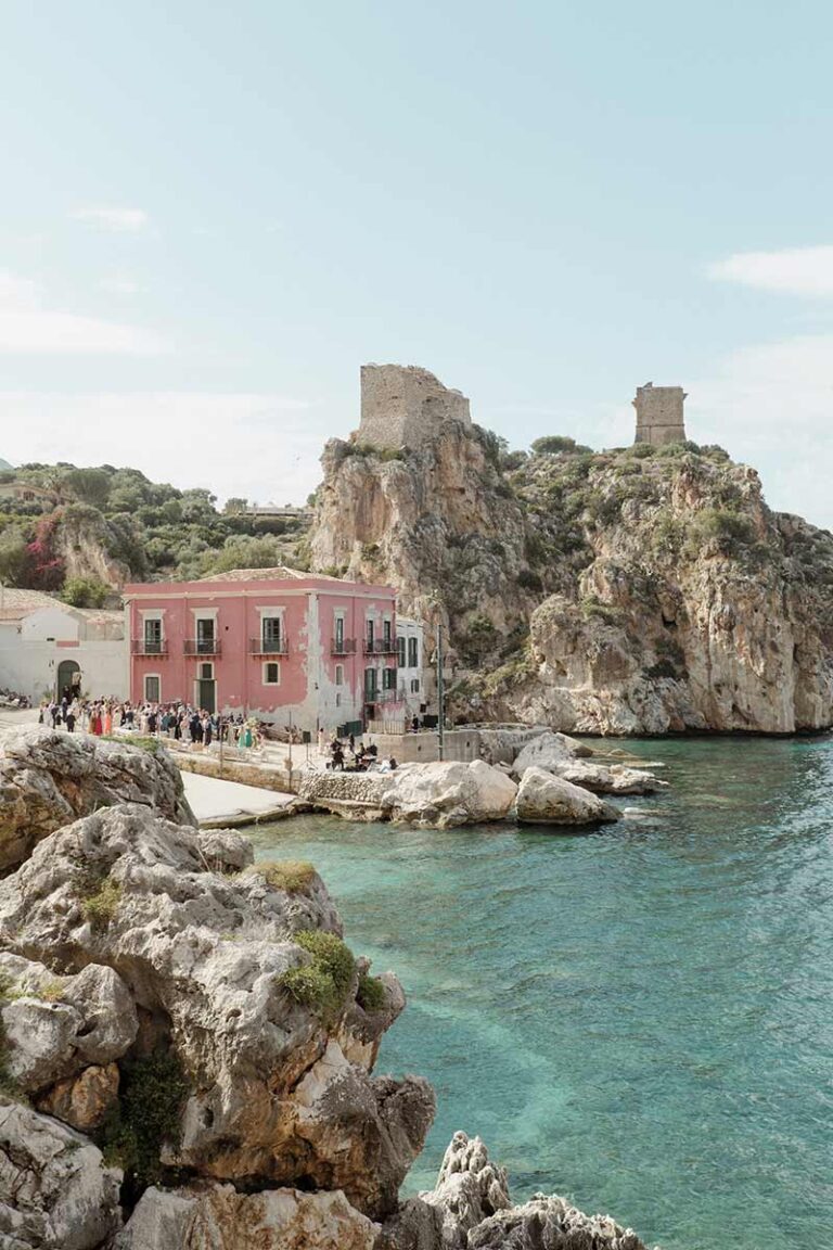 Seaside cove with a pink house and a watchtower on the rocks, Sicily, Wedding Sicily