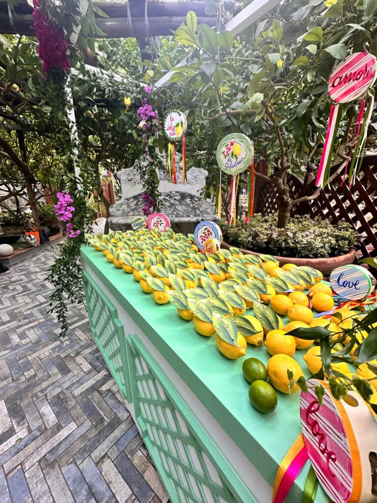 A mint-green table heaped with lemons under a garden pergola, painted signs among the leaves, Capri, Weddings Amalfi