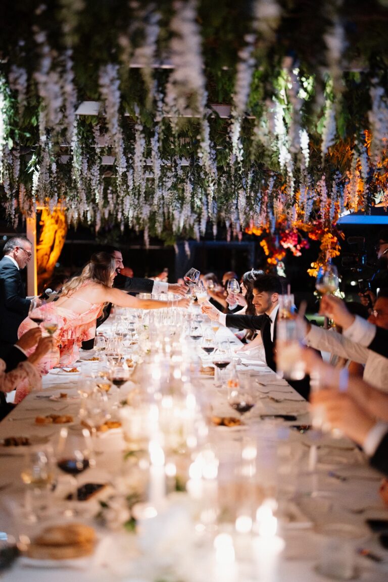 Dinner at an imperial table under a ceiling of hanging white and lilac flowers, candles down its length, Punta Tragara, Capri, Weddings Amalfi