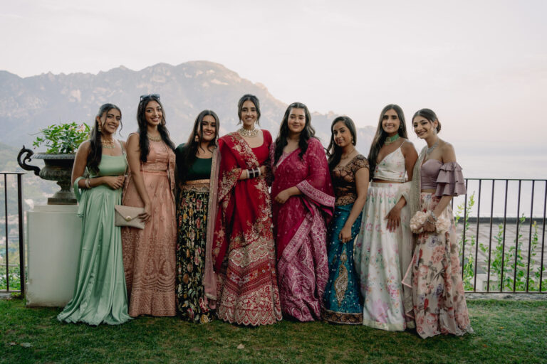 Guests in lehengas and saris along a garden balustrade above the sea, Ravello, Weddings Amalfi