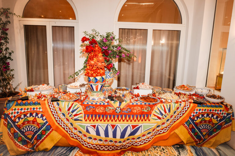 A buffet laid on a printed majolica-pattern cloth, a painted urn of red flowers at its centre, Capri, Weddings Amalfi