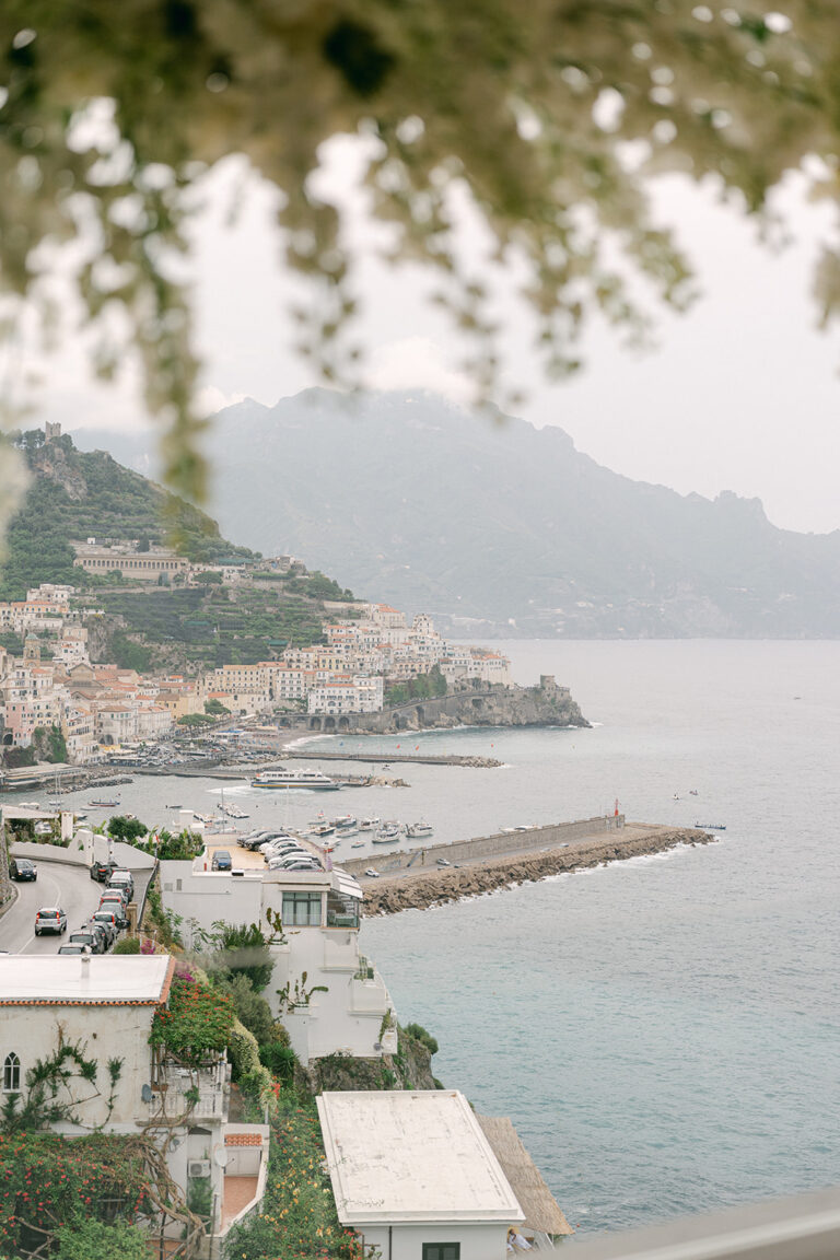 Amalfi and its harbour seen from above through branches, the harbour wall running out below, Weddings Amalfi
