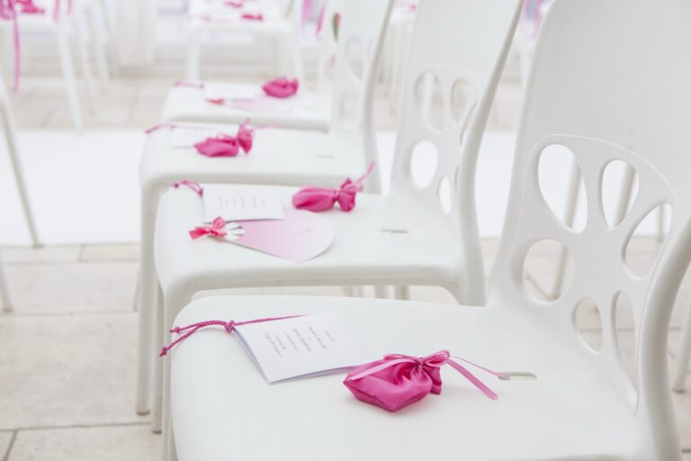 Order-of-service cards and pink satin favours left on each ceremony chair, WEM Eventi