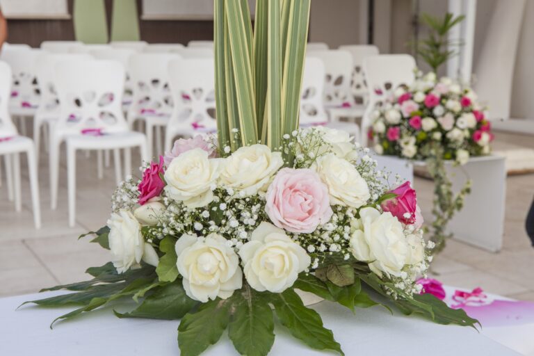 White and pink roses with gypsophila and tall leaves at the head of a ceremony aisle, WEM Eventi