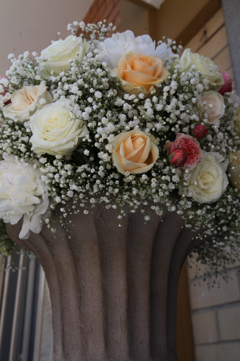 Cream and peach roses in a cloud of gypsophila in a stone urn, WEM Eventi