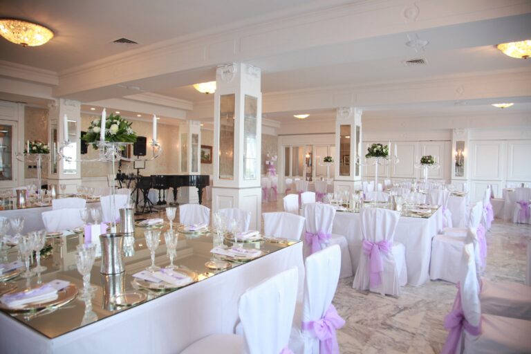 A reception room in white and lilac with mirrored long tables, crystal glassware and a grand piano, WEM Eventi
