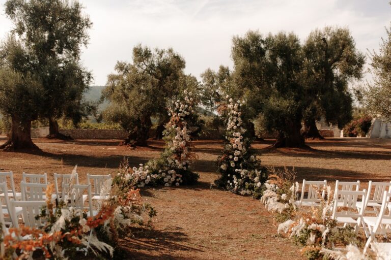 A floral arch rising among centuries-old olive trees, Puglia, White Emotion