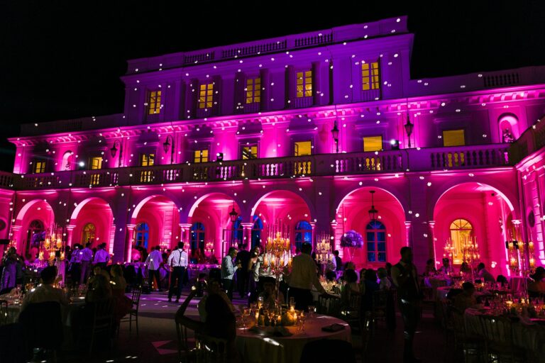 A villa lit magenta at night, an arched loggia set for dinner, Rome, White Emotion