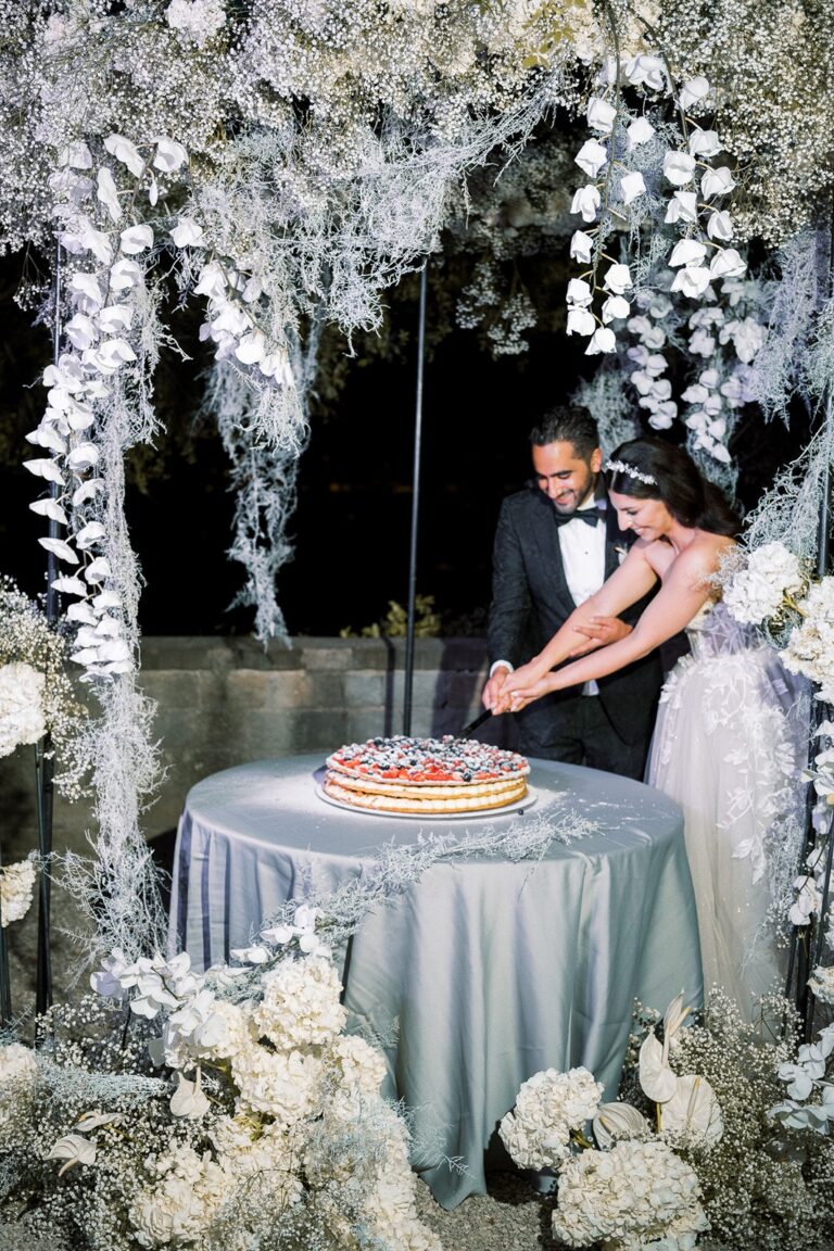 Cutting the cake beneath a hanging installation of white blooms, Tuscany, White Emotion