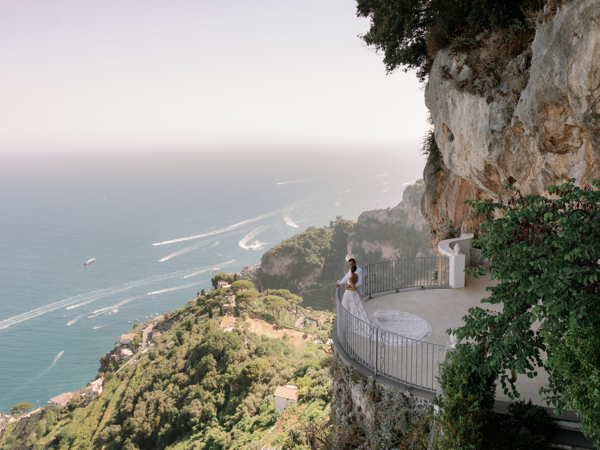 Aerial: a couple embracing on a cliffside terrace above the Amalfi Coast, White Emotion
