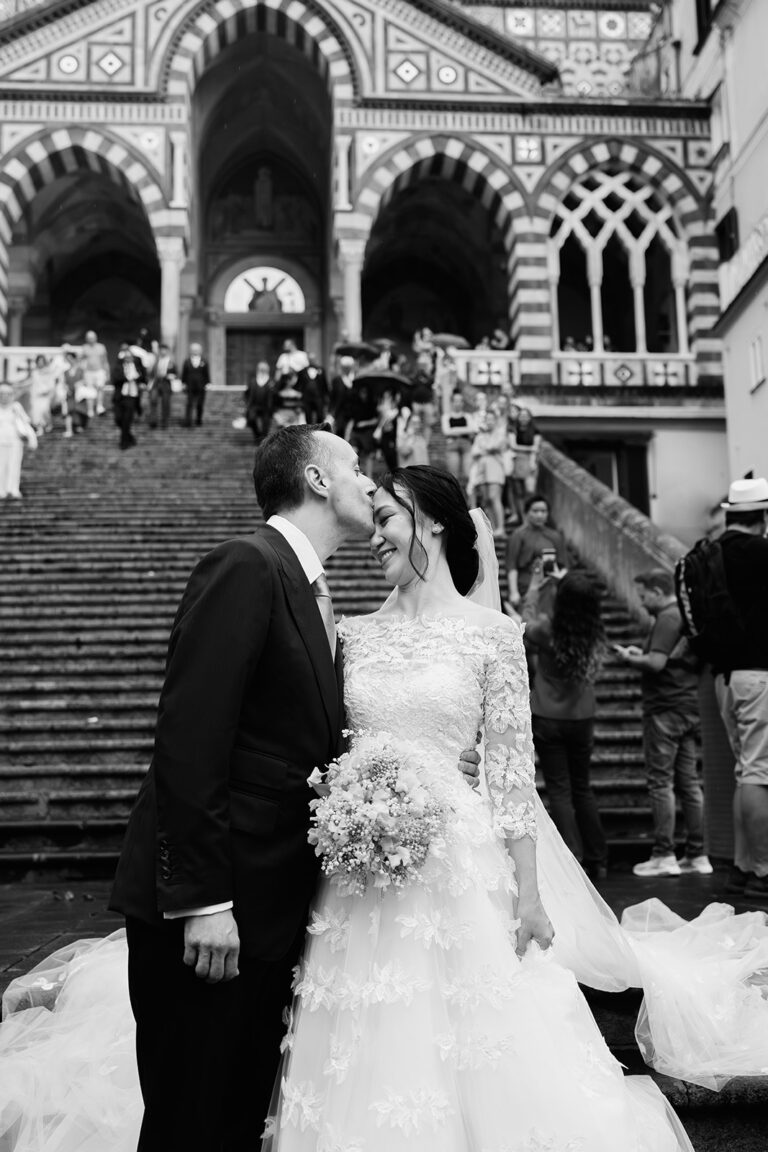 Black and white: a couple on the steps of the Duomo di Amalfi, its striped facade behind them, White Emotion