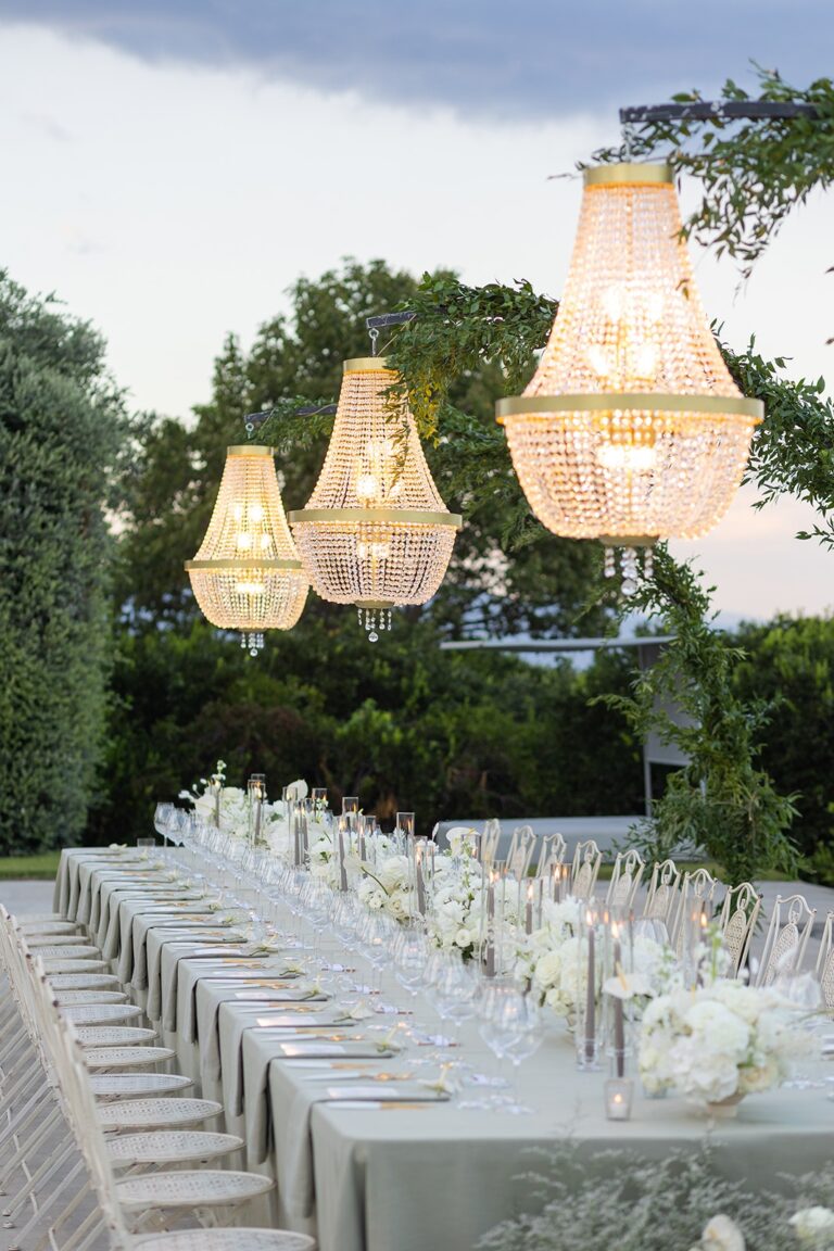 A long candlelit table beneath crystal chandeliers at dusk, Sicily, White Emotion