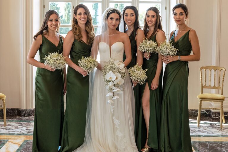 A bride and five bridesmaids in emerald green, a marble Roman interior, White Emotion