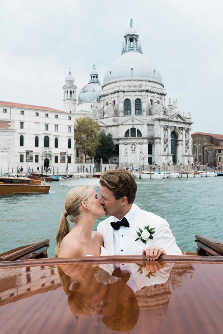Phoebe and Peder kiss in a launch in front of Santa Maria della Salute, Venice, Whitesfilm Wedding Videography