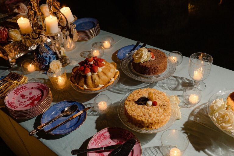A candlelit dessert table with painted plates at a wedding in Sicily, Whitesfilm Wedding Videography