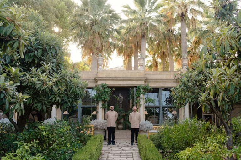 Two guests on a garden path among palms at a Sicilian villa, Whitesfilm Wedding Videography
