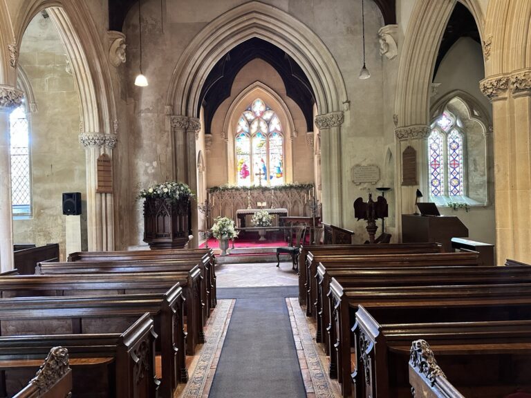 The nave of St Swithun's church, with box pews leading to the altar and stained glass east window, Wickham House