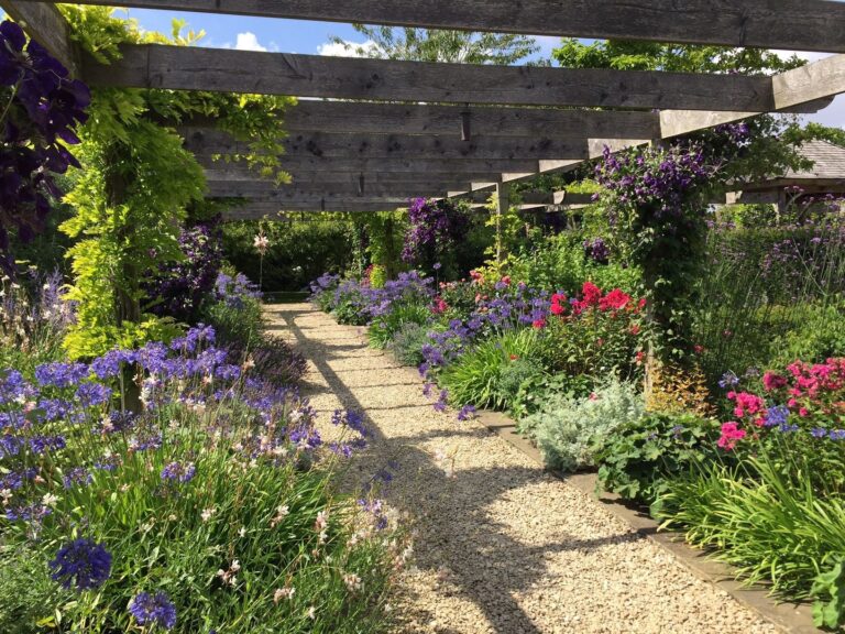 The long pergola in the walled garden, planted with clematis, agapanthus and roses, Wickham House