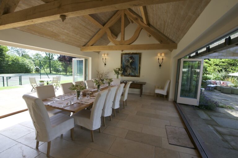 The Pavilion dining room with its folding doors open to the tennis court and the walled garden, Wickham House