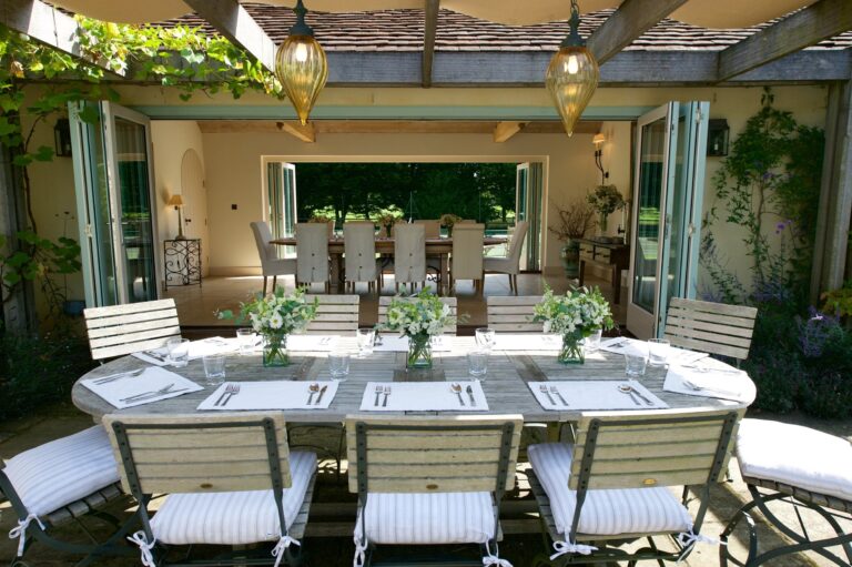 A table laid under the vine-covered pergola outside the Pavilion, Wickham House