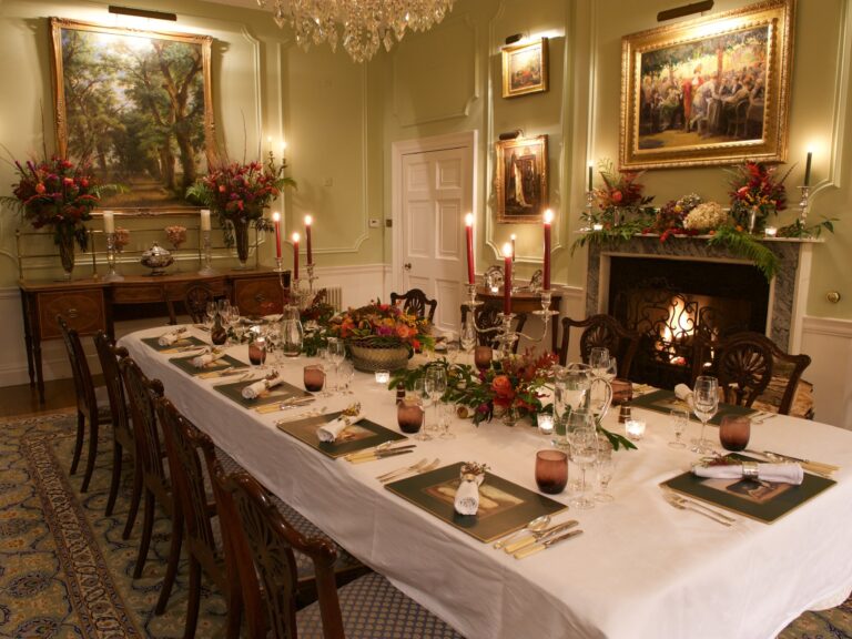 The dining room in the house laid for a candlelit dinner, with the fire lit, Wickham House