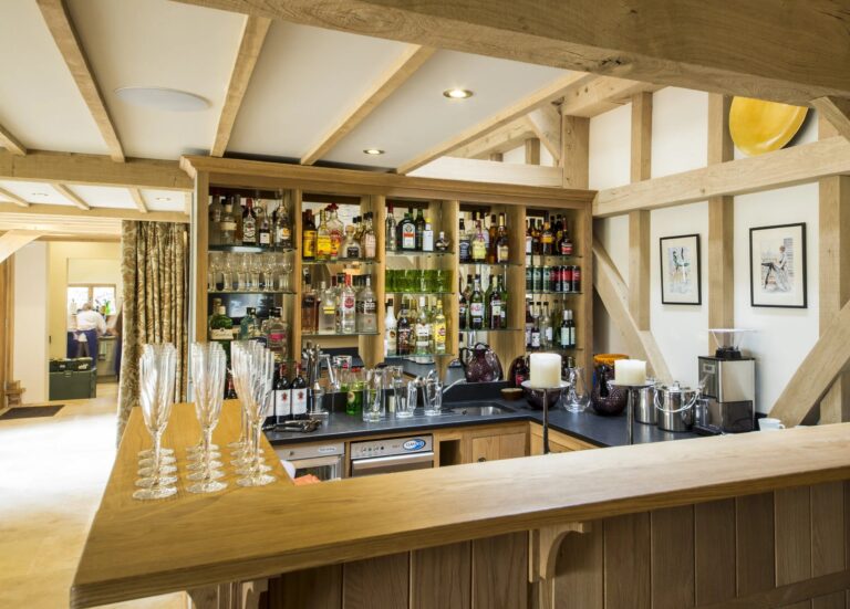 The bar in the Barn, with its shelves of bottles and glasses set out, Wickham House