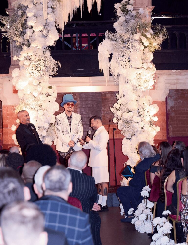 A dense white floral arch frames the ceremony, The Londoner, Wildabout
