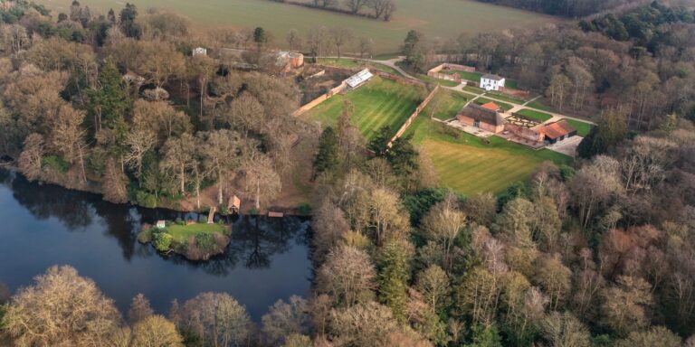 Worstead Park from the air in early spring, with the lake and its small island, the boathouse, the walled gardens, Estate Cottage and The Woodyard, Worstead Estate