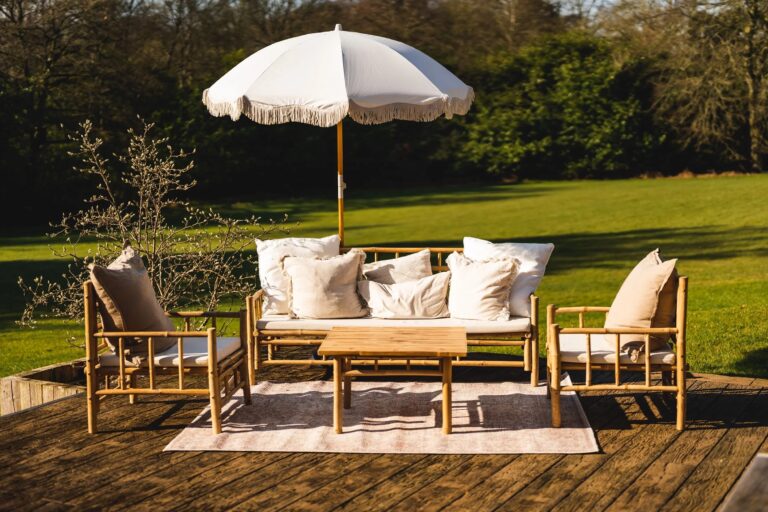 A bamboo lounge set and parasol on the decking beside the lawn, Worstead Estate