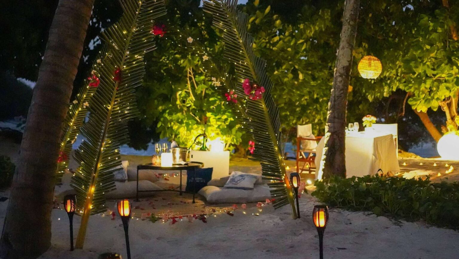 Private dining set on the sand at night