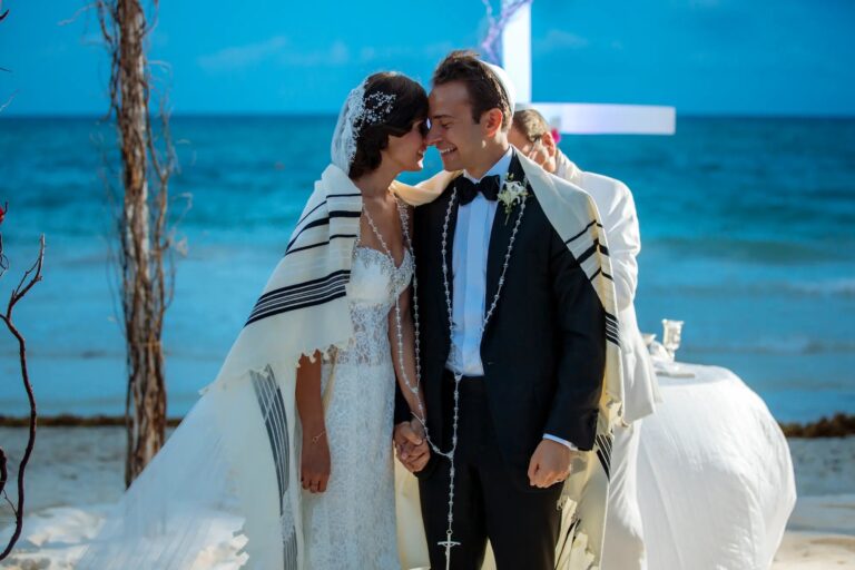 A couple in a tallit and a black tie on the beach after their ceremony, YD Events