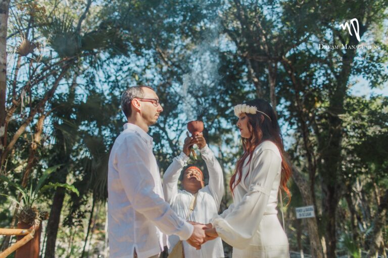 A symbolic ceremony in a forest clearing, with the officiant between the couple, YD Events