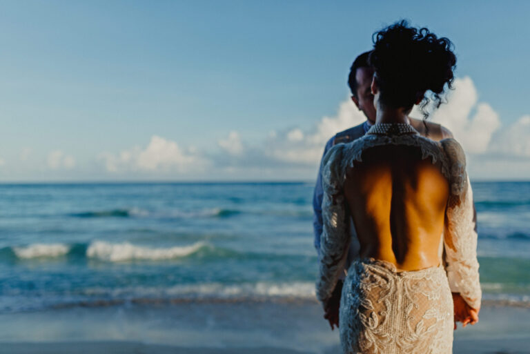 A bride in a lace gown looking out to the sea, YD Events