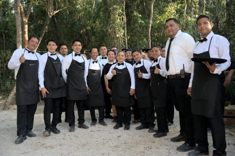 The banquet service team in black aprons gathered in a jungle clearing, YD Events