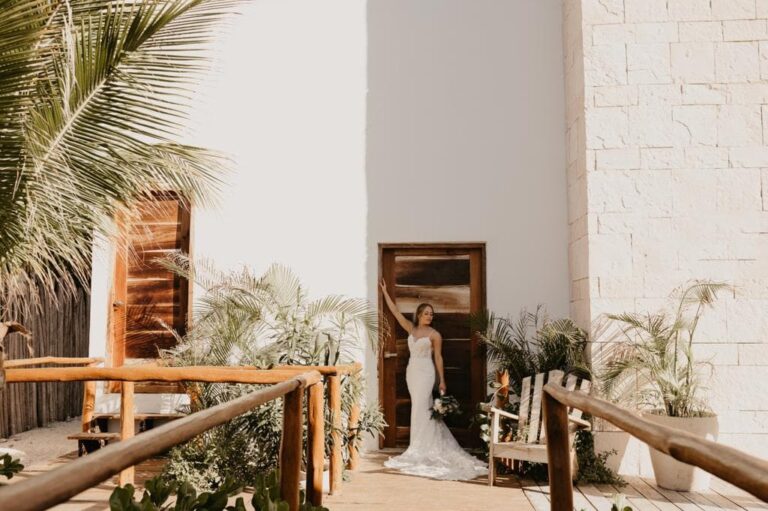 A bride in a doorway at a private venue with palms and white walls, YD Events