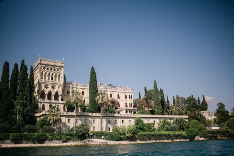 A ceremony beneath a Venetian Gothic arcade open to Lake Garda, seen from behind the seated guests, Your Secret Tuscany